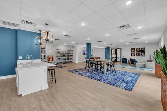 A kitchen with a white island and blue walls.