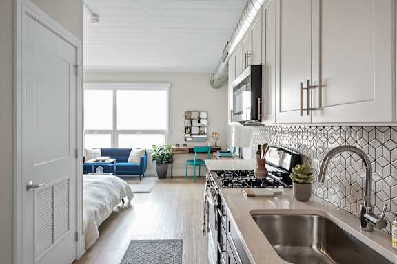 A kitchen with a stove top oven and a sink.