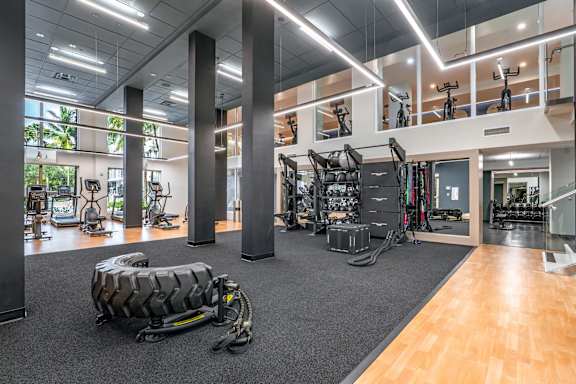 A gym with a variety of equipment including treadmills, weights, and exercise bikes.