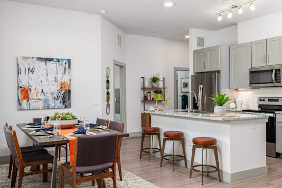 A modern kitchen with a dining table set for four.