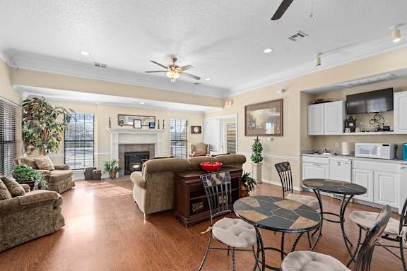 A living room with a fireplace and a dining table  at Chapel Ridge of Stillwater, Stillwater, OK, 74075