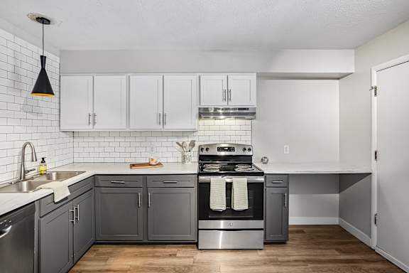 A kitchen with a stove top oven and a dishwasher.