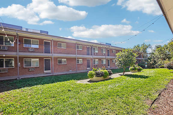 A red brick building with a green lawn in front.