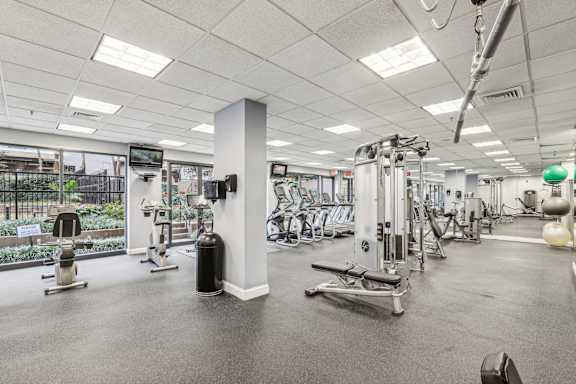 a gym with weights and other exercise equipment in a building with glass doors