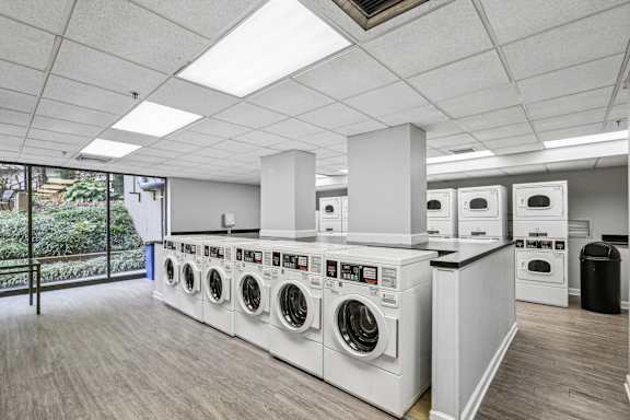 a laundry room with washers and dryers and a row of washing machines