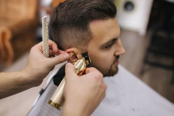 a man getting his hair cut at a barber shop