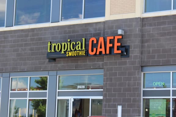 a sign for tropical cafe on the side of a building