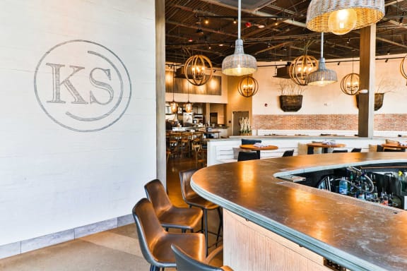 a bar in a restaurant with a ks logo on the wall