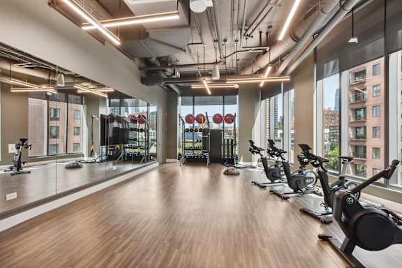 a workout room with weights and yoga machines and a large window  at Cassidy on Canal, Chicago, 60606