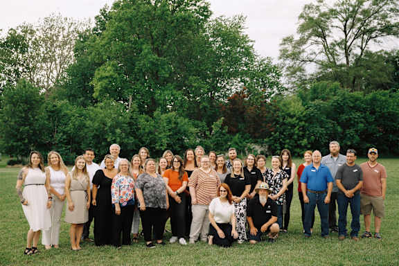 A group of people are posing for a photo in a field.