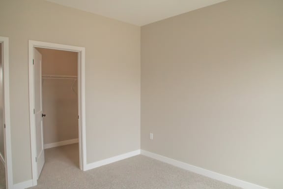 A room with a carpeted floor and a white door.