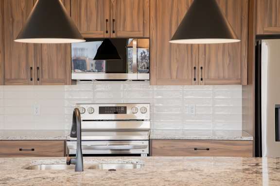 A modern kitchen with a stainless steel oven and wooden cabinets.