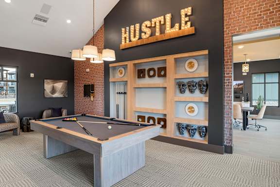 A pool table is in the middle of the room.