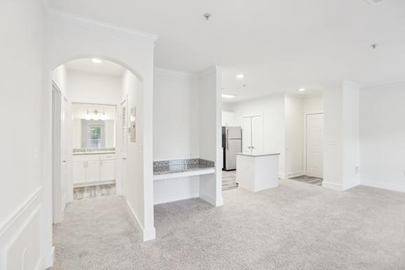 A white room with a carpeted floor and a bench.