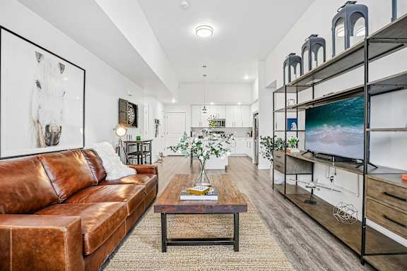 A living room with a brown leather couch and a wooden coffee table.