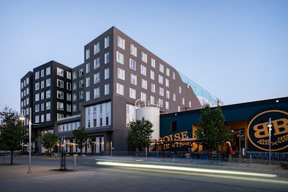 A modern building with a dark facade and a sign that reads "BOISE BREWING COMPANY".