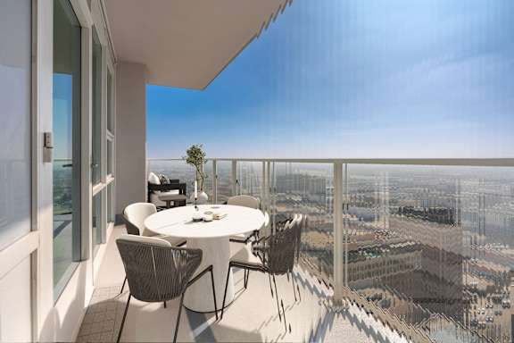 A balcony with a table and chairs overlooking a cityscape.