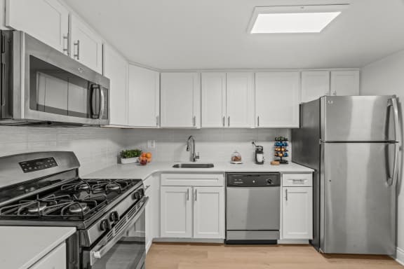 a kitchen with white cabinets and stainless steel appliances  at Chestnut Hill Village, Pennsylvania, 19118