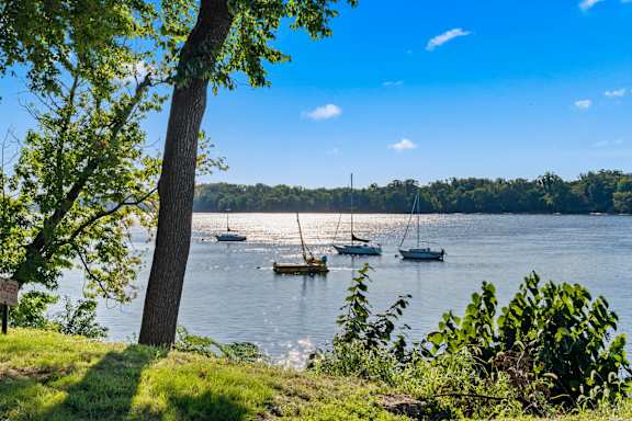A serene lake with boats and trees in the background.
