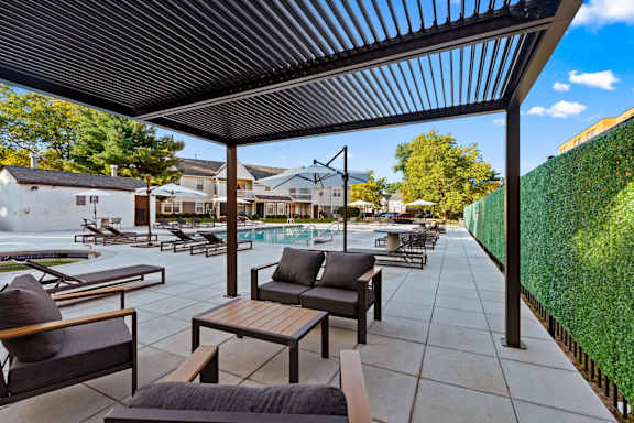 A patio with a table and chairs under a roof.