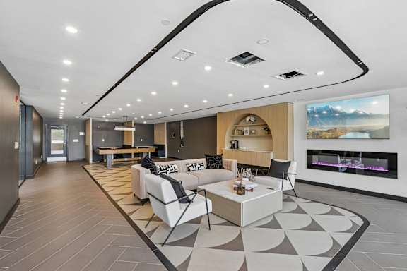 A modern living room with a fireplace and a large painting on the wall.
