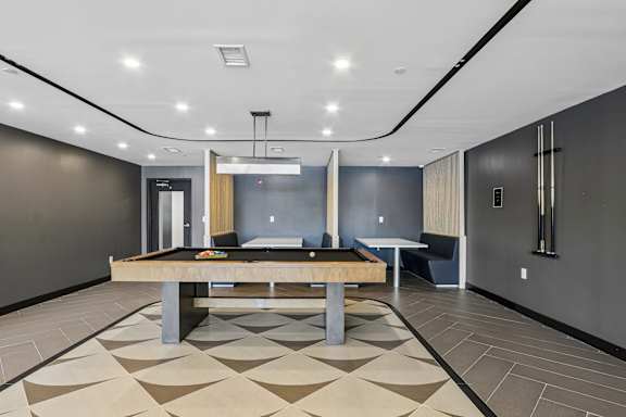 A room with a pool table and a bench.