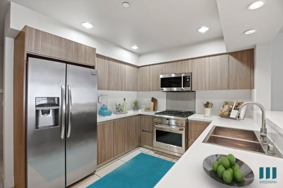 a kitchen with wooden cabinets and a blue rug