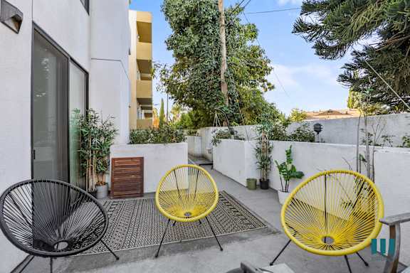 an apartment building with a balcony and a walkway with plants