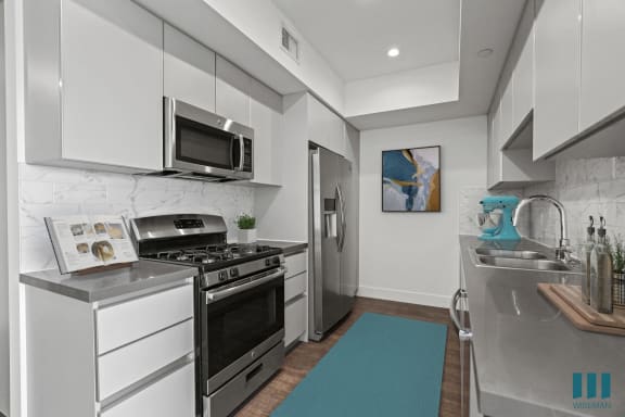 a kitchen with gray cabinets and white countertops
