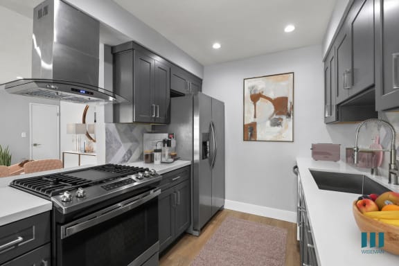 a kitchen with stainless steel appliances and white cabinets