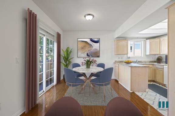 a living room with a blue couch and a table with yellow chairs