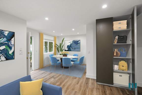 A modern living room with a blue couch and a painting on the wall.
