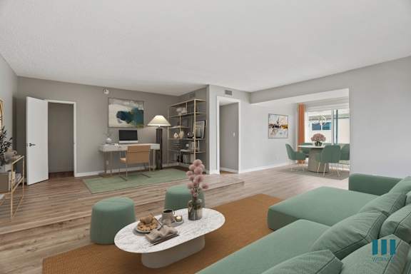 a living room with a fireplace and a dining room in the background