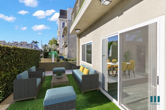 a patio with chairs and a table outside of a house