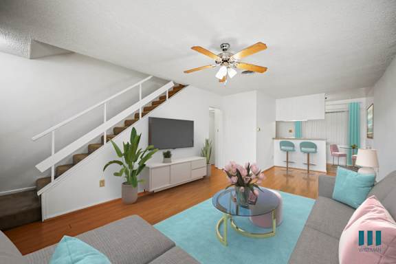 A living room with a grey couch and a blue rug.