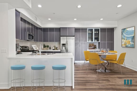 a kitchen with gray cabinets and white countertops