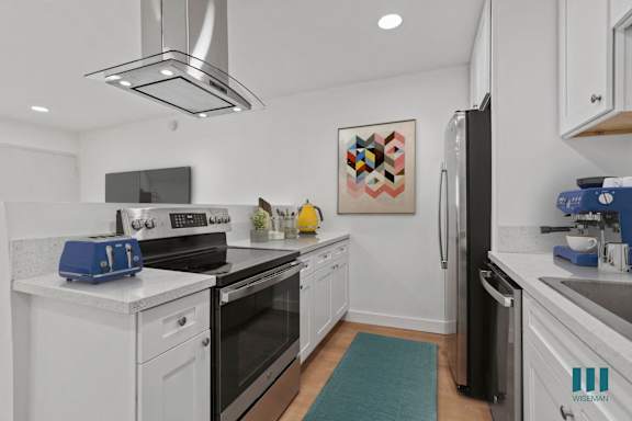 a kitchen with stainless steel appliances and white cabinets