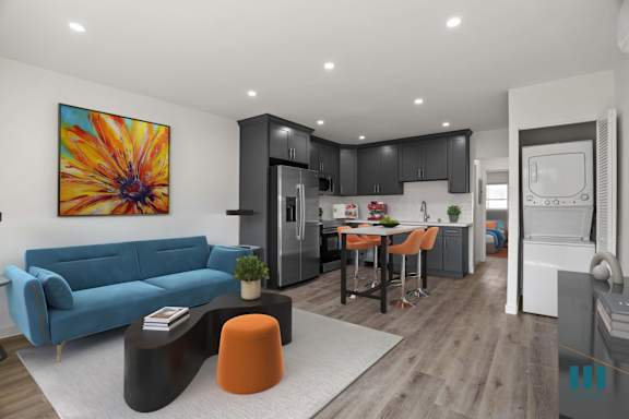 a living room with a blue couch and a table and chairs