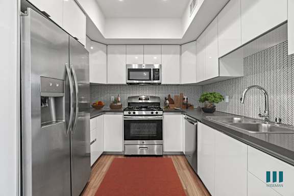 a kitchen with gray cabinets and white countertops