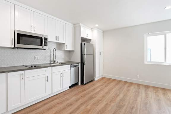 Studio Apartment Kitchen including Two-Burner Stovetop,Dishwasher, Full-Size Refrigerator, Microwave, and Plenty of Cabinet Storage