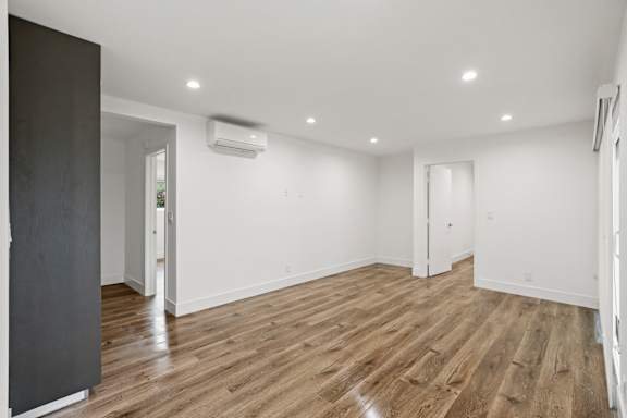 Large Bedroom with Wall Heater, Cabinet Storage, and Window Shades