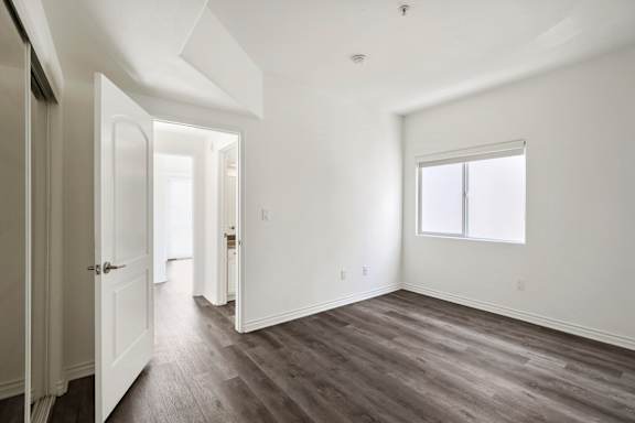 Bedroom with Closet, Window, and Vinyl Flooring