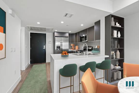 A kitchen with a bar area and chairs.