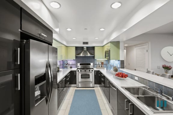 a kitchen with gray cabinets and white countertops