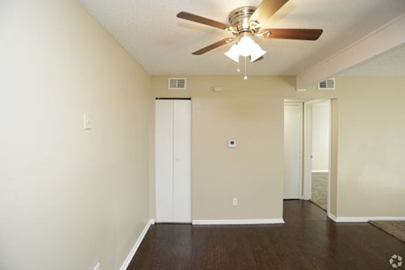 Large dark wood panel flooring and utility closet with ceiling fan