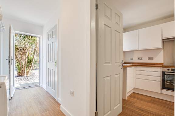 A white interior with a door open to a balcony.