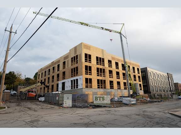 A construction site with a partially built brick building and a crane.