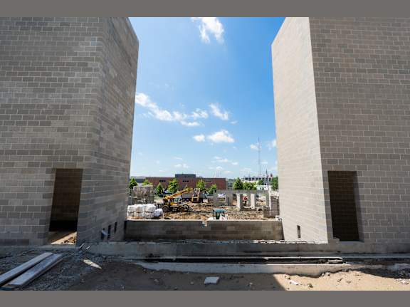 Two large grey brick pillars with a construction site in the background.