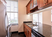 Thumbnail 20 of 23 - A kitchen with a refrigerator, sink, and cabinets.