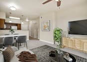 Thumbnail 1 of 17 - A living room with a grey couch and a television.